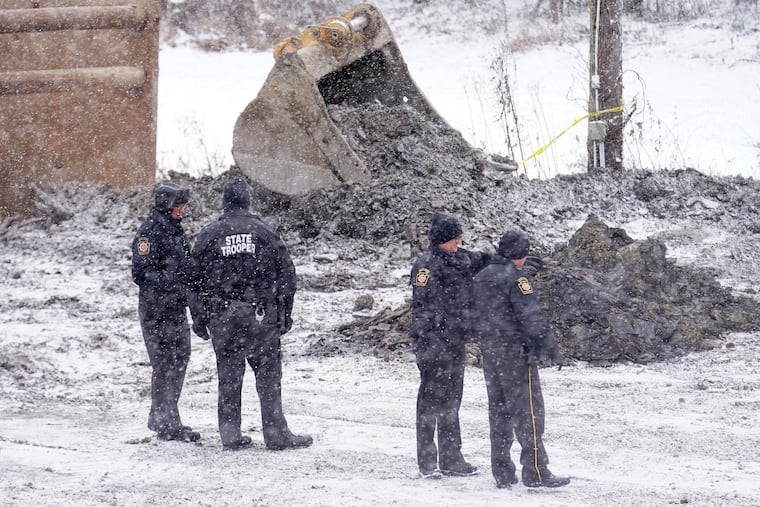 Law enforcement members watch as rescue workers continue to search, Thursday, Dec. 5, 2024, for Elizabeth Pollard, who is believed to have disappeared in a sinkhole while looking for her cat, in Marguerite, Pa.