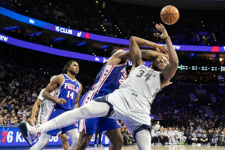 Guerschon Yabusele (center) of the Sixers and Wendell Carter of the Magic battle for a rebound during the 2nd half of their game at the Wells Fargo Center on Dec. 4, 2024.