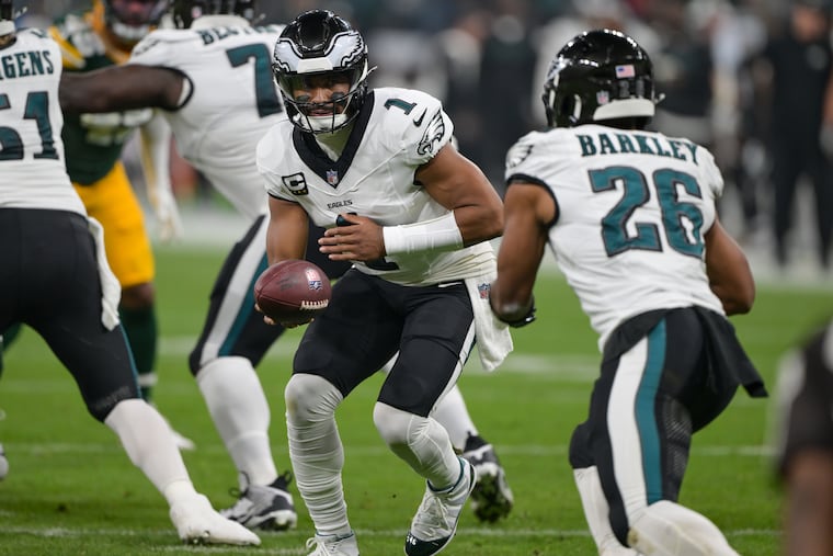 Eagles quarterback Jalen Hurts hands off to Saquon Barkley during the opener, when Barkley rushed for 109 yards.